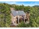 Aerial view of the rear of the home, showing decks, a patio with a fire pit, and spiral staircase at 30205 Telluride Ln, Evergreen, CO 80439
