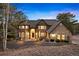 Stunning two-story home featuring stone and stucco accents, arched entryway, and lush landscaping at 30205 Telluride Ln, Evergreen, CO 80439