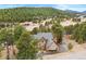 Spacious home exterior shot, nestled in the trees of a wooded community on a paved road at 30205 Telluride Ln, Evergreen, CO 80439