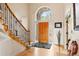 Grand foyer with hardwood floors, a staircase, and a decorative front door with an arched transom window at 30205 Telluride Ln, Evergreen, CO 80439