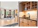 Charming wet bar with light wood cabinets and black countertops, complemented by dining area at 30205 Telluride Ln, Evergreen, CO 80439