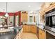 Modern kitchen showcasing a large island with gas cooktop, granite countertops, light wood cabinets and stainless appliances at 30205 Telluride Ln, Evergreen, CO 80439