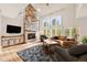 Bright living room with stone fireplace, high ceilings, and large windows offering scenic views at 30205 Telluride Ln, Evergreen, CO 80439