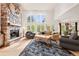 Spacious living room with stone fireplace, high ceilings, and scenic views through large windows at 30205 Telluride Ln, Evergreen, CO 80439