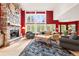 Inviting living room showcasing a stone fireplace, large windows with great views, and comfortable seating at 30205 Telluride Ln, Evergreen, CO 80439