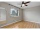 A neutral bedroom boasts a ceiling fan, a window letting in light, and wood-look flooring at 3355 S Flower St # 166, Lakewood, CO 80227