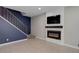 Cozy living room featuring a modern fireplace with a mounted TV and adjacent staircase at 3355 S Flower St # 166, Lakewood, CO 80227