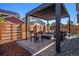 Cozy backyard patio with modern pergola, stone pavers, fire pit and comfortable seating at 10179 E 59Th North Pl, Denver, CO 80238