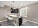 Finished basement wet bar featuring black cabinets, pendant lighting, and a window at 10179 E 59Th North Pl, Denver, CO 80238