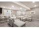 Finished basement with a carpeted floor, wet bar with modern stools and a large sectional sofa with a small table at 10179 E 59Th North Pl, Denver, CO 80238