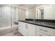 Modern bathroom with a walk-in glass shower, a granite vanity top and white cabinets with brushed gold hardware at 10179 E 59Th North Pl, Denver, CO 80238