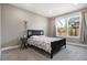 Cozy bedroom with large windows, carpet flooring, a dark-wood bed frame, and curtains at 10179 E 59Th North Pl, Denver, CO 80238
