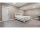 Basement bedroom featuring a white bed with patterned bedding on a carpeted floor with neutral colored walls and a white door at 10179 E 59Th North Pl, Denver, CO 80238