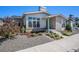 Landscaped front yard with a walkway to the front door of a home with stone facade at 10179 E 59Th North Pl, Denver, CO 80238