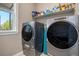 Laundry room with side-by-side washer and dryer units, complete with shelving for laundry essentials at 10179 E 59Th North Pl, Denver, CO 80238