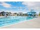 Community pool with a slide, lap lanes, and lounge area on a sunny day at 10179 E 59Th North Pl, Denver, CO 80238