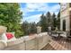 Back deck with comfortable seating area, dining table and lush green trees surrounding the area at 5159 Serene View Way, Parker, CO 80134