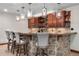 Finished basement wet bar boasts granite countertops, stone base, and glass shelving at 5159 Serene View Way, Parker, CO 80134