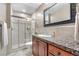 A bright bathroom featuring a glass enclosed shower with tile surround and granite countertops at 5159 Serene View Way, Parker, CO 80134