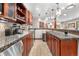 An open concept kitchen featuring granite countertops and custom cherry wood cabinets with display shelving at 5159 Serene View Way, Parker, CO 80134