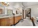 Spacious primary bathroom with double sinks, custom cabinetry, walk in closet, and tiled flooring at 5159 Serene View Way, Parker, CO 80134