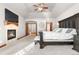 Bright primary bedroom featuring a stone fireplace, a tray ceiling, plush carpet, and decorative lighting at 5159 Serene View Way, Parker, CO 80134