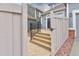 Private backyard with wood deck, stairs, a fenced gate, and low-maintenance landscaping at 1518 Whitehall Dr, Longmont, CO 80504