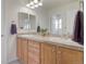 Bathroom with double sinks, wood cabinets, and light fixtures above the mirror at 1518 Whitehall Dr, Longmont, CO 80504