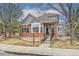 Charming home with brick and gray siding, landscaping, and inviting front porch at 1518 Whitehall Dr, Longmont, CO 80504
