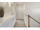 Upstairs hallway with white walls, carpet flooring, and decorative plant at 1518 Whitehall Dr, Longmont, CO 80504
