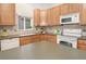 Kitchen with wood cabinets, tile backsplash, and a central island at 1518 Whitehall Dr, Longmont, CO 80504
