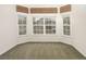 Bright living room featuring three large windows with neighborhood views and neutral décor at 1518 Whitehall Dr, Longmont, CO 80504