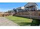 Expansive backyard with a retaining wall, artificial grass, and views of the neighborhood at 26304 E 4Th Pl, Aurora, CO 80018