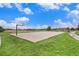 Community basketball court surrounded by grass and trees under a clear sky at 26304 E 4Th Pl, Aurora, CO 80018