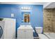 Stylish bathroom with blue walls, updated vanity, toilet, shower and washer/dryer combo at 26304 E 4Th Pl, Aurora, CO 80018