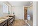 Bright bathroom featuring dual sinks, granite counters, modern fixtures, and a glass enclosed shower at 26304 E 4Th Pl, Aurora, CO 80018