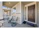 Cozy front porch with seating area, neutral siding, and a welcoming front door at 26304 E 4Th Pl, Aurora, CO 80018