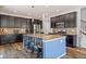 This spacious kitchen features dark wood cabinetry, stainless steel appliances, and a large center island at 26304 E 4Th Pl, Aurora, CO 80018