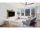 Stylish living room with a large window, modern ceiling fan, and comfortable seating at 26304 E 4Th Pl, Aurora, CO 80018