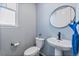 Well-lit powder room with a pedestal sink, oval mirror, and a modern toilet at 26304 E 4Th Pl, Aurora, CO 80018