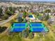 Aerial view of community tennis courts, pool and clubhouse with mature trees and manicured landscaping at 6997 S Poplar Way, Centennial, CO 80112