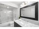 Bright bathroom with marble countertop, modern vanity, glass shower door, and a large framed mirror at 6997 S Poplar Way, Centennial, CO 80112