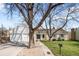 Charming brick home with a well-manicured lawn, mature trees, and a welcoming front entrance at 6997 S Poplar Way, Centennial, CO 80112