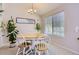 Bright dining room with wood table, white chairs, and a modern chandelier, perfect for Gathering gatherings at 1470 S Quebec Way # 244, Denver, CO 80231