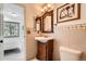 Charming bathroom with a wooden vanity, neutral tile, and updated fixtures at 4832 E Kentucky Ave # E, Denver, CO 80246