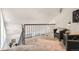 Carpeted loft space with black metal railing and a sitting area featuring leather chairs at 4832 E Kentucky Ave # E, Denver, CO 80246
