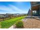 Landscaped backyard with grassy slope, gravel area, stone path, wooden fence, and views of neighborhood homes at 18212 W 95Th Pl, Arvada, CO 80007