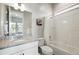 Modern bathroom featuring a shower-tub combination, granite vanity, and a stylish mirror, providing ample lighting at 18212 W 95Th Pl, Arvada, CO 80007