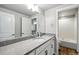 Bright bathroom featuring a granite-topped vanity, white cabinets, and a combined shower and bathtub at 18212 W 95Th Pl, Arvada, CO 80007
