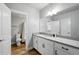 Bright bathroom featuring a granite-topped vanity, white cabinets, and a combined shower and bathtub at 18212 W 95Th Pl, Arvada, CO 80007